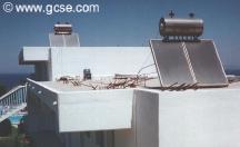 solar panels on a roof producing hot water which is stored in their tanks - click to enlarge